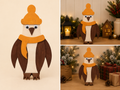 Handmade wooden penguin Christmas decoration with orange bobble hat and scarf, shown in lifestyle settings with fairy lights and festive greenery