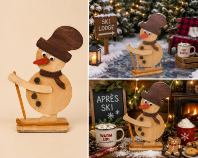 Handmade wooden skiing snowman decoration in small size, with top hat, scarf and ski pole, shown freestanding as a Christmas display piece