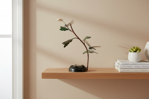 Dragonfly Dance sculpture displayed on a warm interior oak shelf
